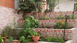 A brick wall with a tiled border, potted plants, and a staircase.
