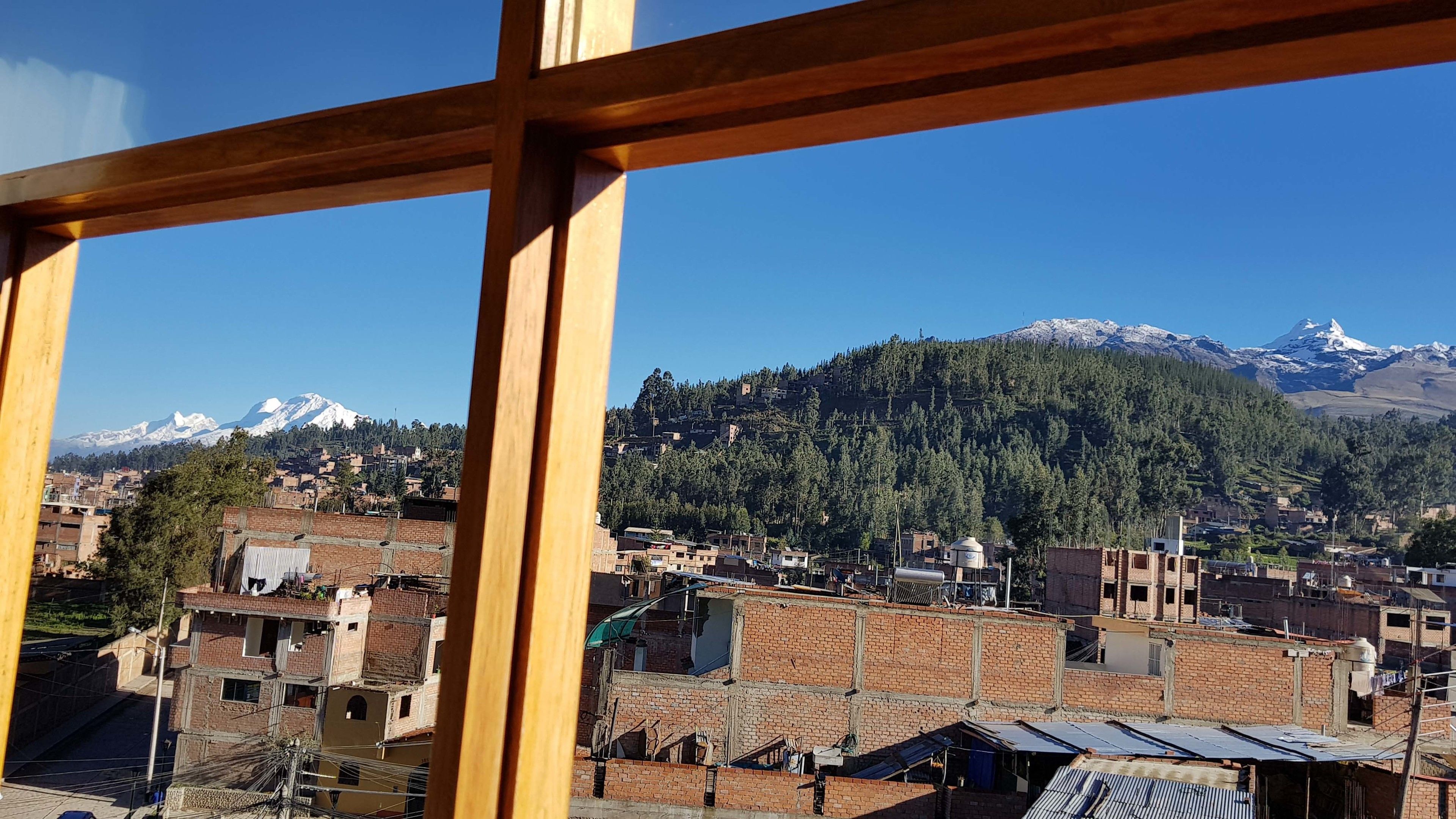 Vista de un pueblo con edificios de ladrillo y una cadena montañosa al fondo.