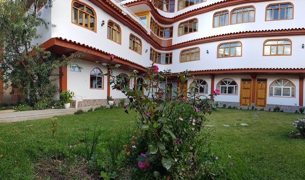 A multi-story building with arched windows and a well-maintained garden. - Hotel Morales (Huaraz)