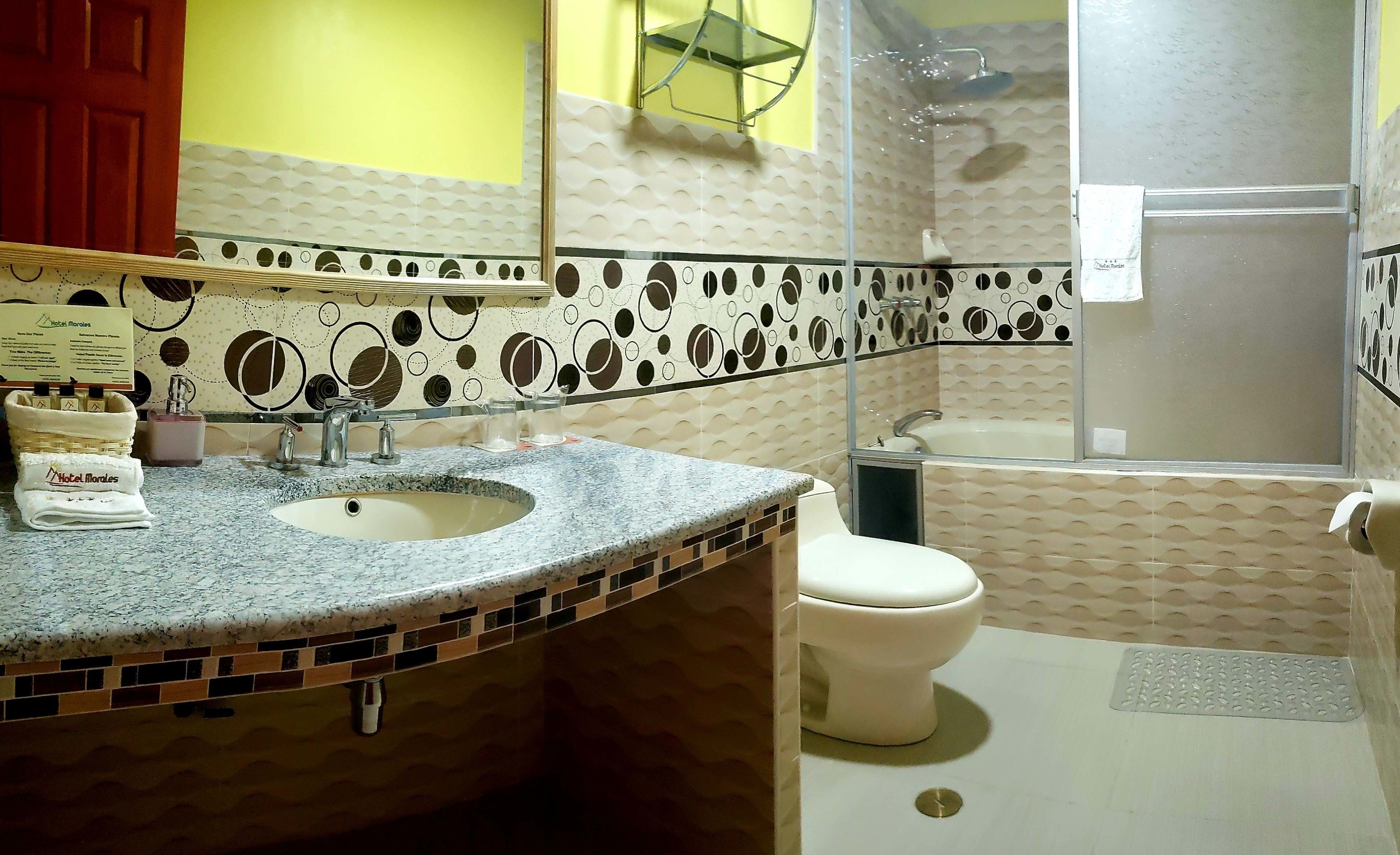A bathroom with a sink, toilet, and shower.