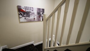 A staircase with patterned carpet and a white railing.