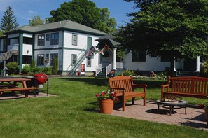 A building with a green and white exterior, a porch with benches, and a flag. - Victoria Resort and Bed & Breakfast (South Haven)