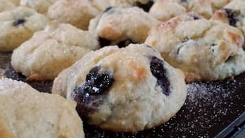 Una bandeja de pasteles recién horneados con trozos de fruta visibles.