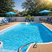 Una piscina al aire libre de temporada, sombrillas