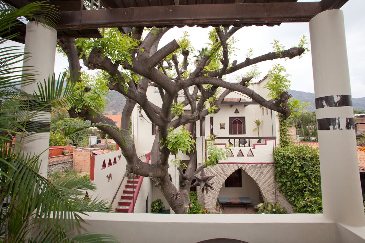 Un edificio tradicional con una escalera que conduce a un espacio cubierto con un banco.
