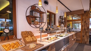 A buffet area with various food items, a clock, and a wooden shelf with decorative items.