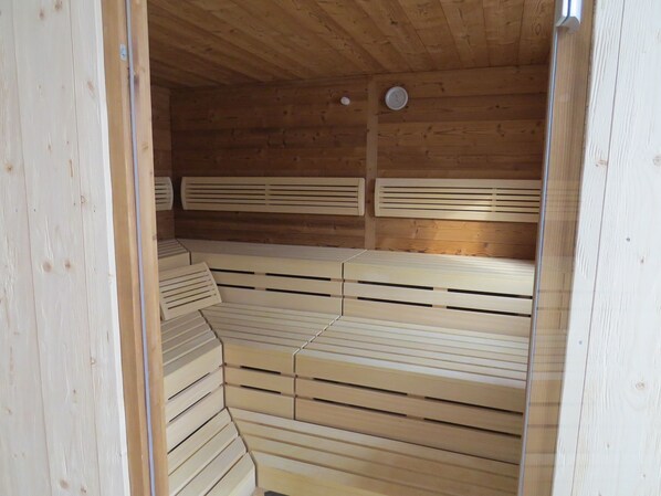 A sauna with wooden benches and slatted backrests. - Apart- and Wellness Hotel Garni Dachsteinresort (Russbach am Pass Gschuett)