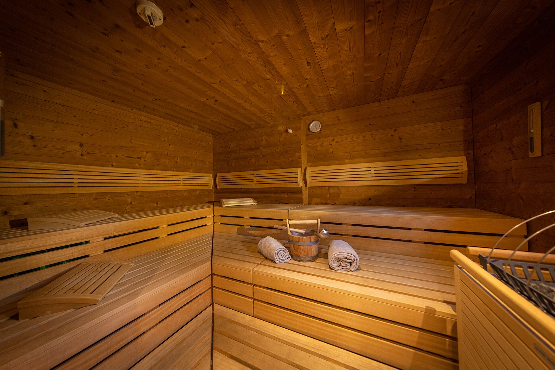 Eine Sauna mit Holzbänken, Holzboden und Holzwänden.