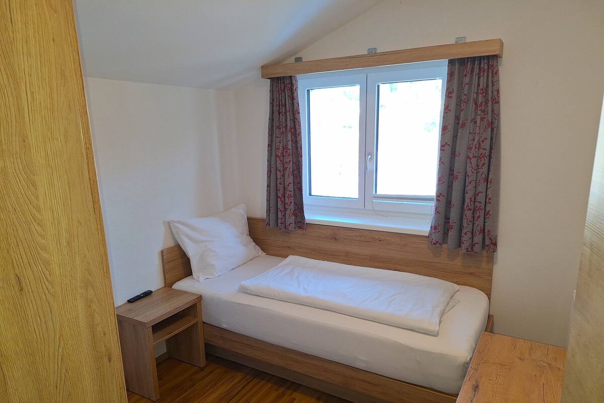 Quarto solteiro básico | Cofres nos quartos, escrivaninha, cortinas blackout, Wi-Fi de cortesia