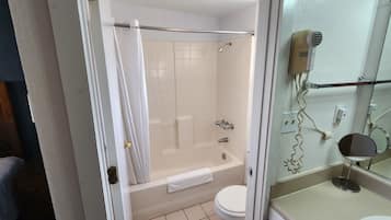 Un baño con bañera, inodoro y zona de ducha.