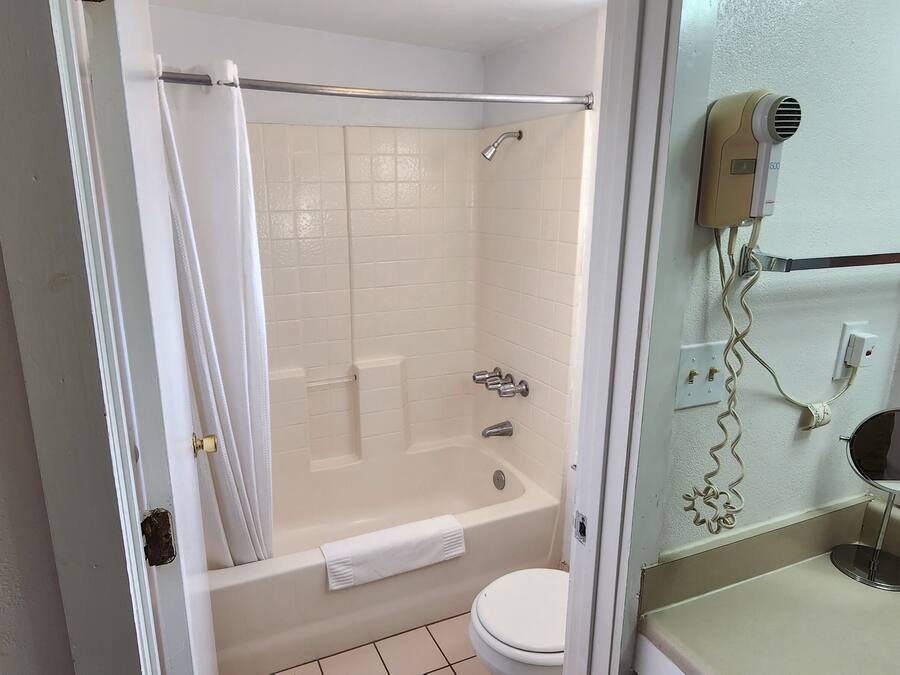 Un baño con bañera, inodoro y zona de ducha.