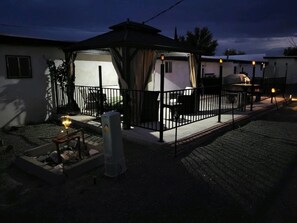 A residential area with a gated entrance, a small garden with a bench, and a covered outdoor seating area.