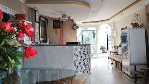 A modern kitchen with a glass island, a refrigerator, and a dining area with a bench. - Hotel Unicornio (Coca)