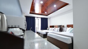 Een hotelkamer met een houten plafond, twee bedden, een bureau met telefoon en een raam met gordijnen.