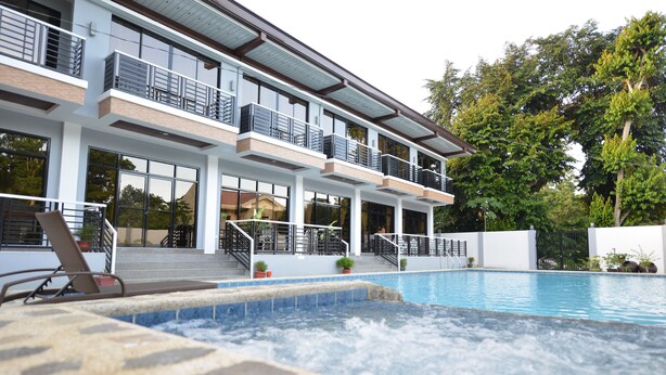 Een modern hotel met een zwembad, meerdere balkons en een wellnessruimte.
