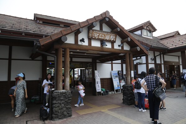Una entrada de estación japonesa tradicional con estructura de madera y señalización.