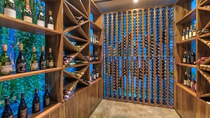 A wine cellar with wooden shelves and racks for wine bottles. - Kemangi Bed & Breakfast (Kuta)