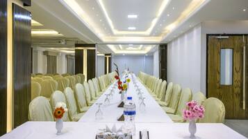 A conference room with a long table, chairs, and floral centerpieces.