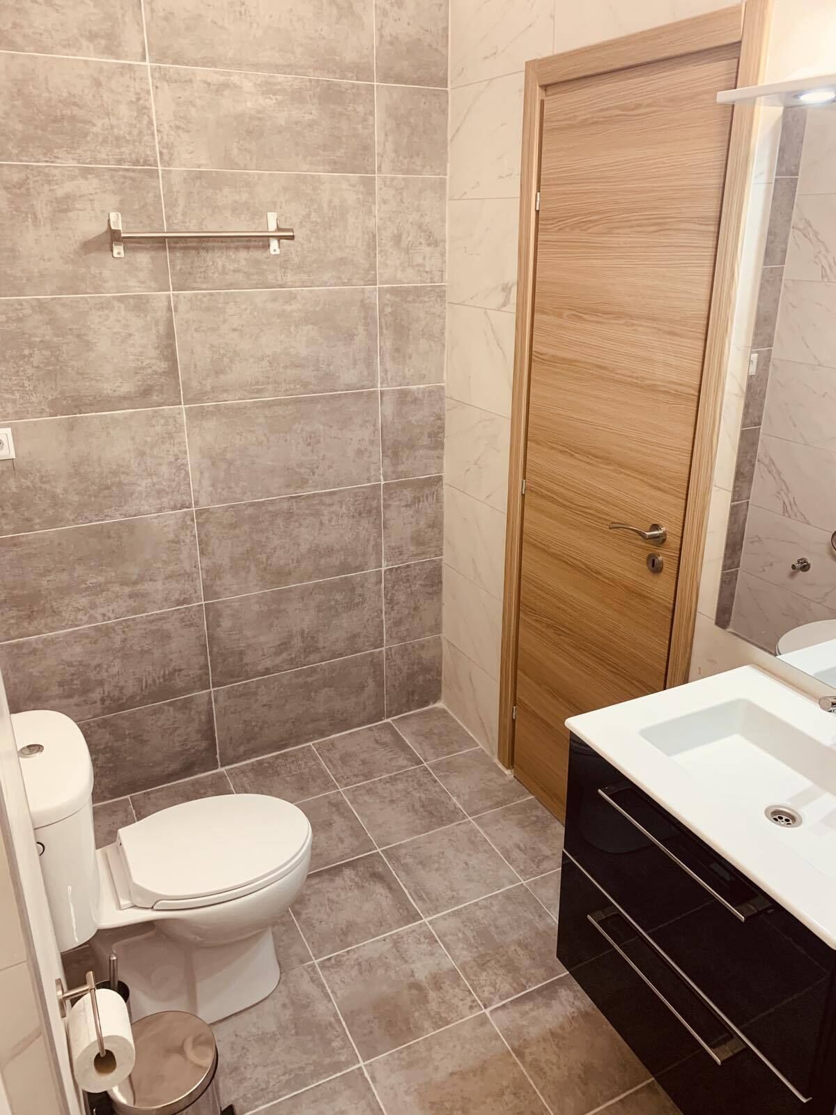 Ein Badezimmer mit Toilette, Waschbecken und Spiegel.