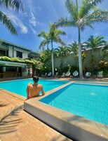 Una piscina al aire libre, sillones reclinables de piscina