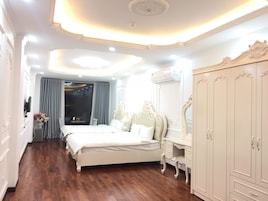 Quarto de hotel com uma cama grande, um guarda-roupa e um espelho.