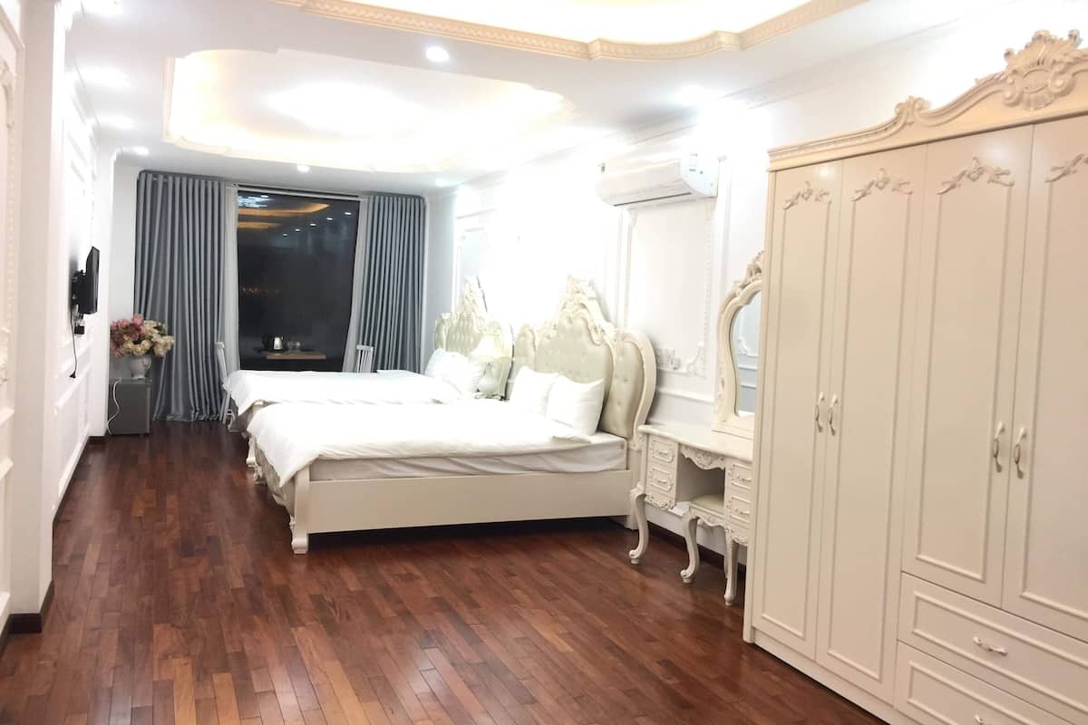 Ein Schlafzimmer mit einem großen Bett, einem Schminktisch mit Spiegel und einem Kleiderschrank.