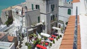 A coastal building complex with multiple balconies and outdoor seating areas. - Locanda Al Castello (Peschici)
