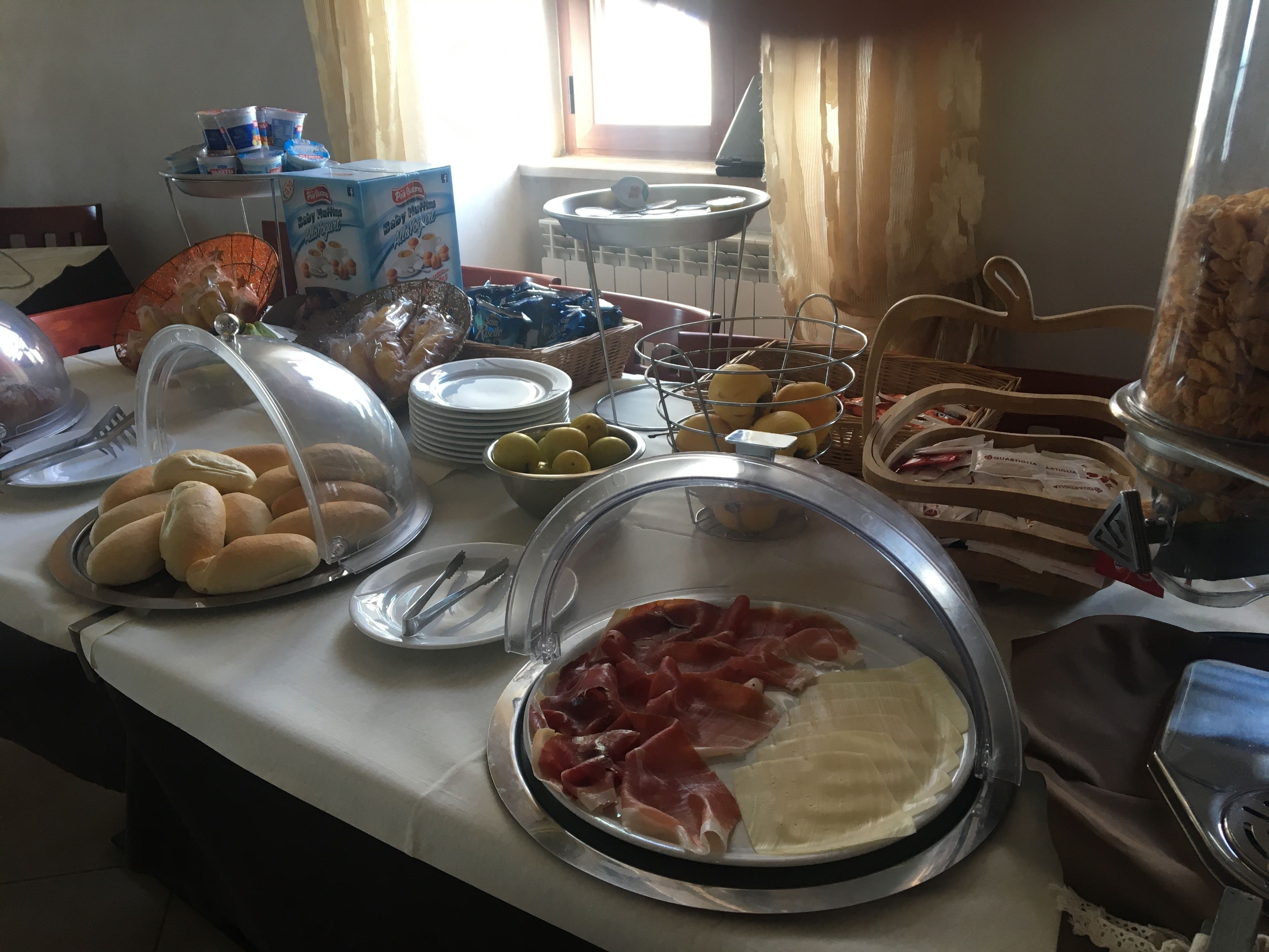 Een buffet met diverse soorten eten, zoals brood, fruit en vlees.