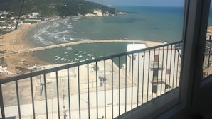 A coastal view from a balcony with a view of the beach, boats, and a rocky shoreline. - Locanda Al Castello (Peschici)