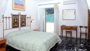A bedroom with a bed, a desk, and a chair. - Locanda Al Castello (Peschici)