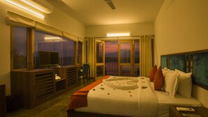 A hotel room with a bed, a TV, a desk, and a balcony with a view. - Vistara Resort (Sulthan Bathery)