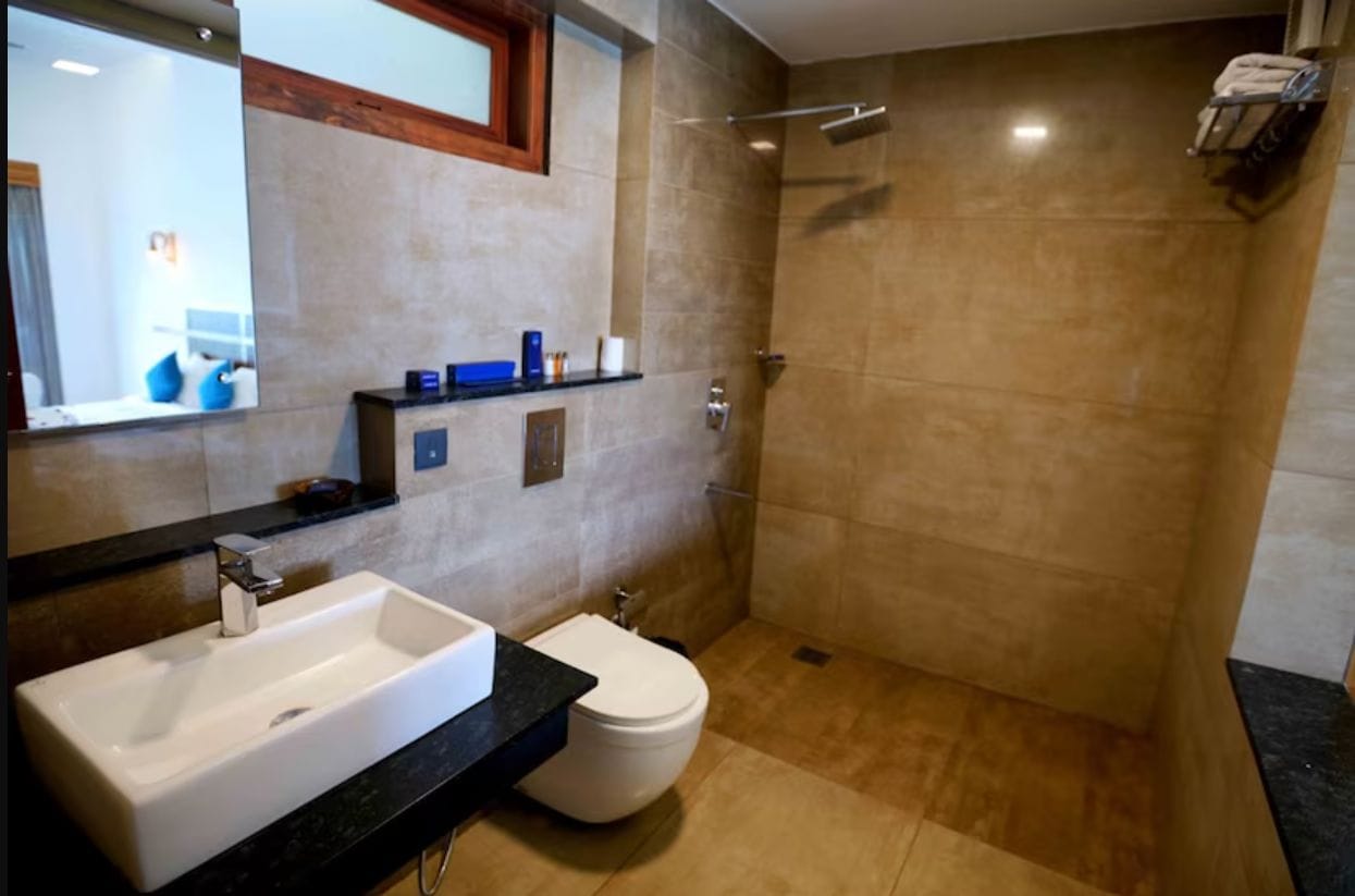 A modern bathroom with a large sink, toilet, and shower.