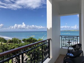 Un balcon avec vue sur l’océan et une chaise.