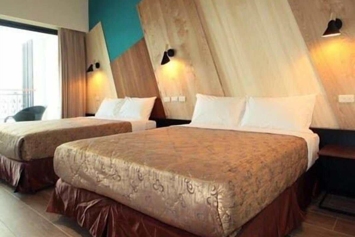 A hotel room with two beds, wooden headboards, and a view of the city.