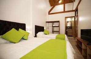 A hotel room with two beds, a TV, and a wooden ceiling. - Whitehouse Bed and Breakfast (Monteverde)