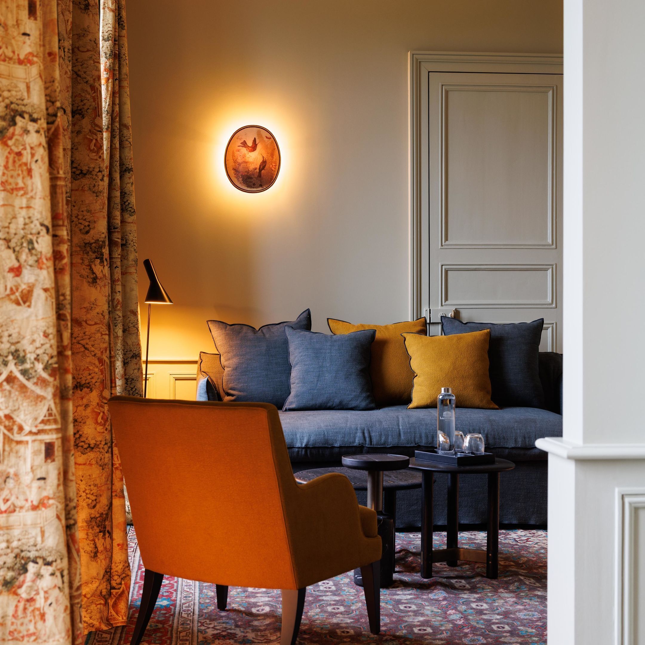 A cozy living room with a sofa, a chair, a lamp, and a small table.