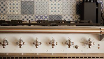 A kitchen with a stove, oven, and tiled backsplash.