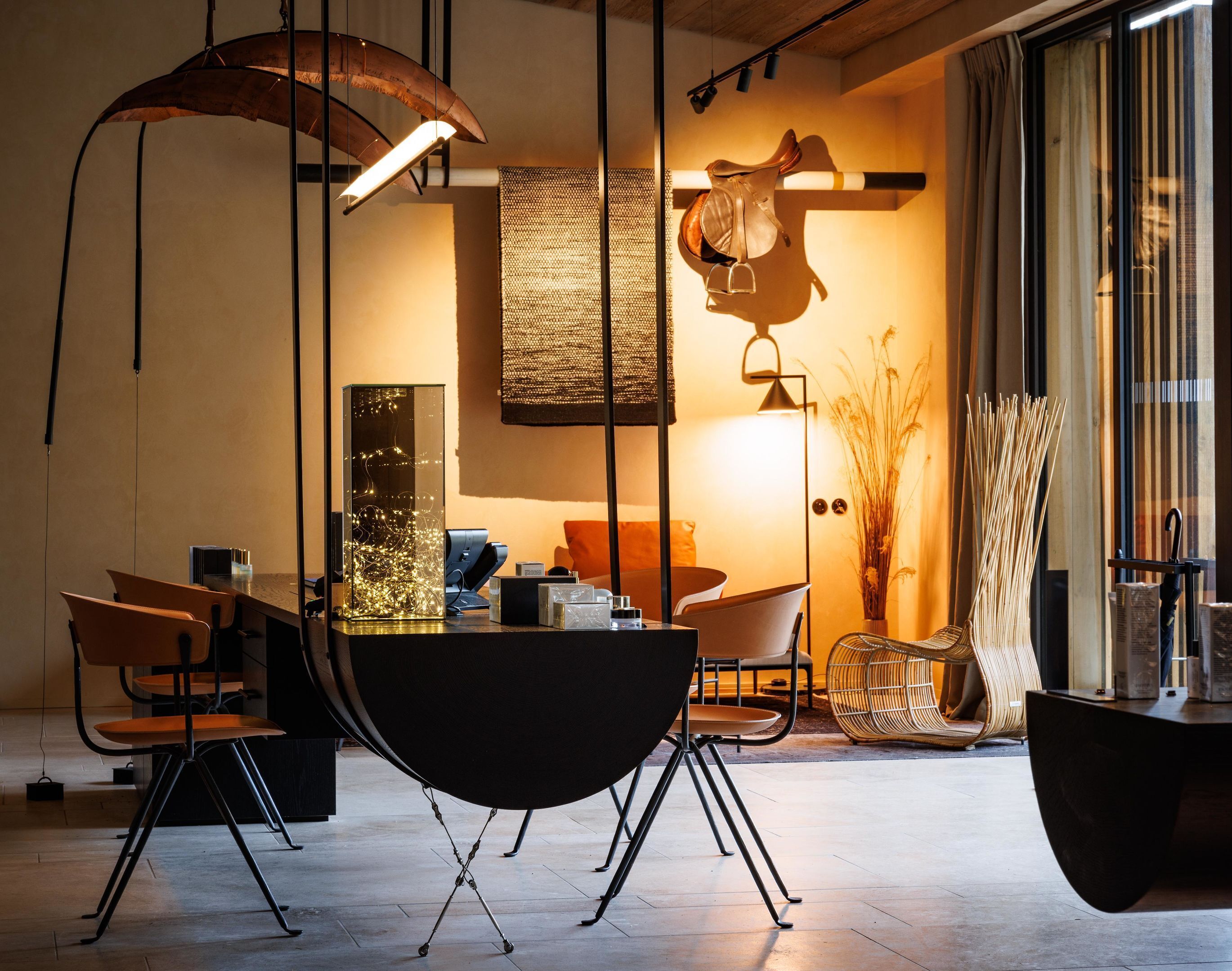 Un espace repas moderne avec une table ronde, des chaises et des luminaires suspendus.