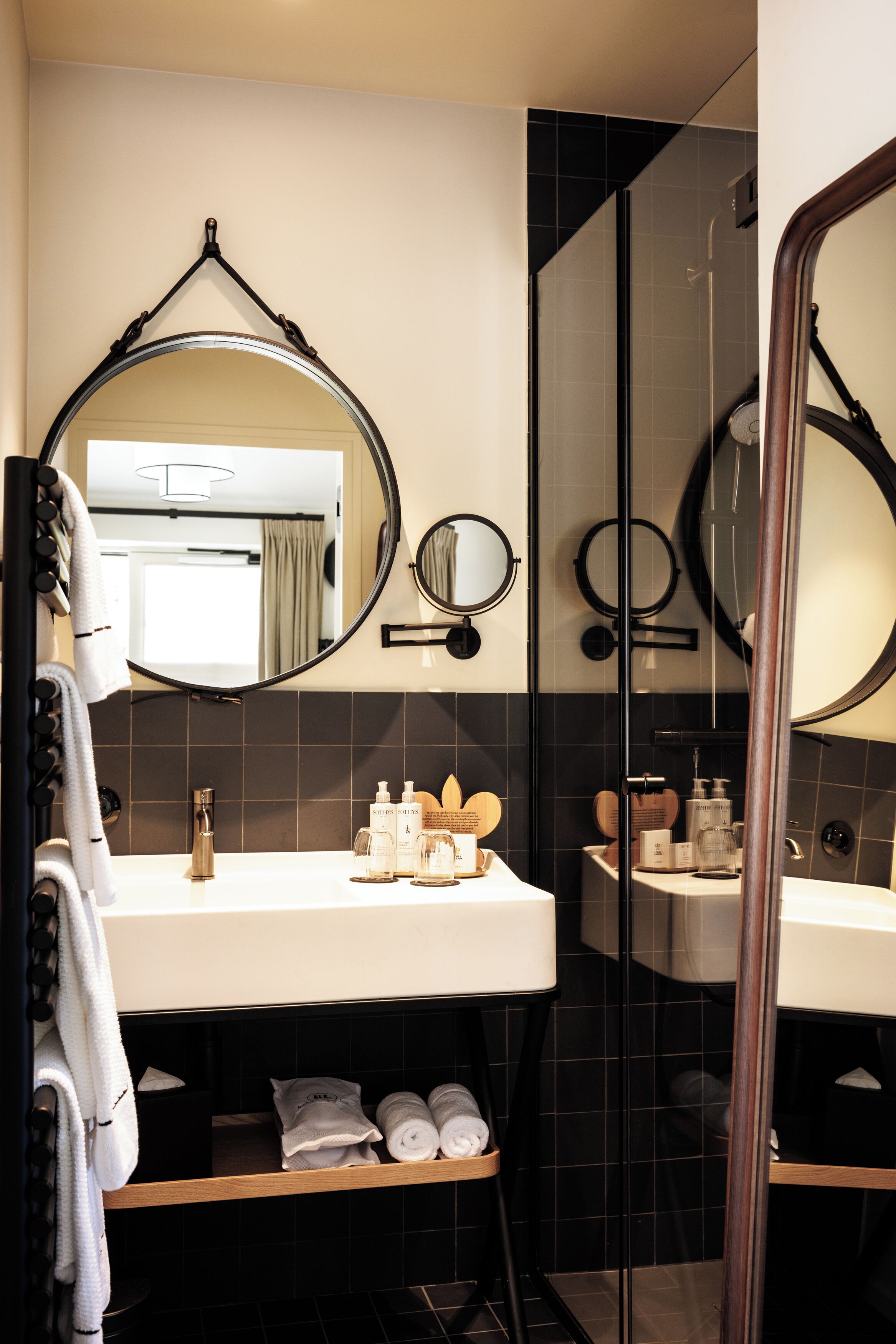 Une salle de bain moderne avec deux lavabos, un grand miroir et une douche à l’italienne.