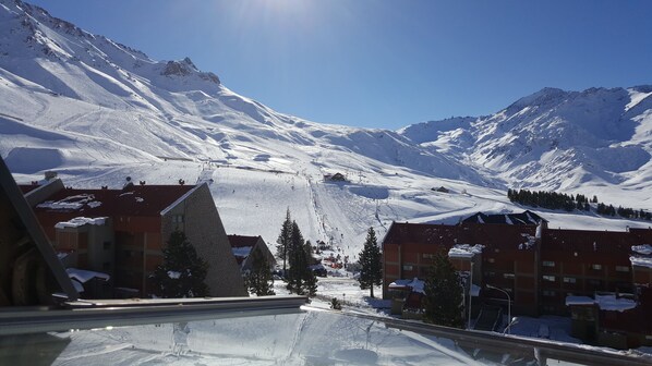 A snow-covered mountain landscape with buildings and ski slopes.