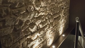 A staircase with a stone wall on one side and a wooden floor. - L'Ecurie d'Obernai (Obernai)