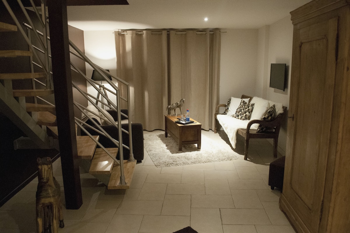 A living room with a staircase, a sofa, a coffee table, and a wooden cabinet.