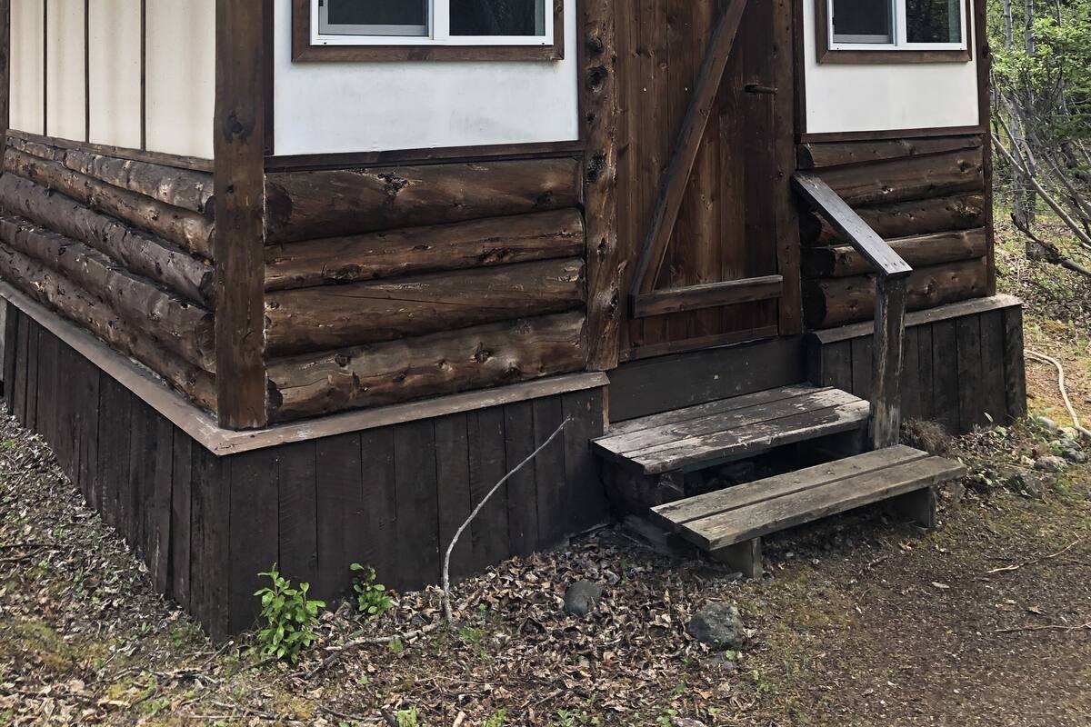 A cabin named Lynx Cabin with a wooden exterior, two windows, and a small porch.