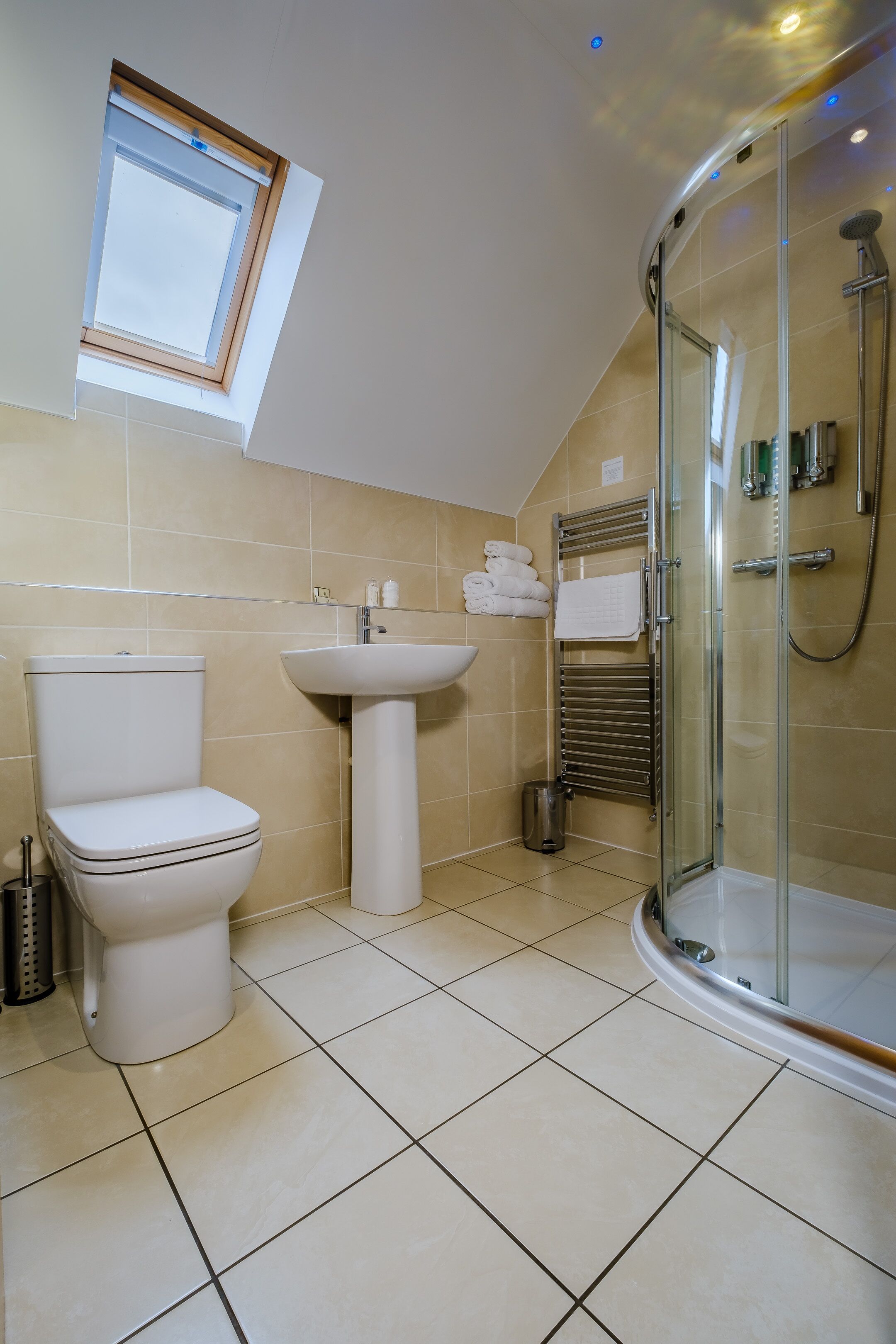 A modern bathroom with a toilet, sink, and glass shower enclosure.