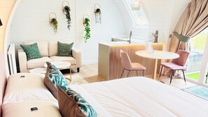 Un interior acogedor y moderno con una cama grande, un sofá, un comedor y una cocina.
