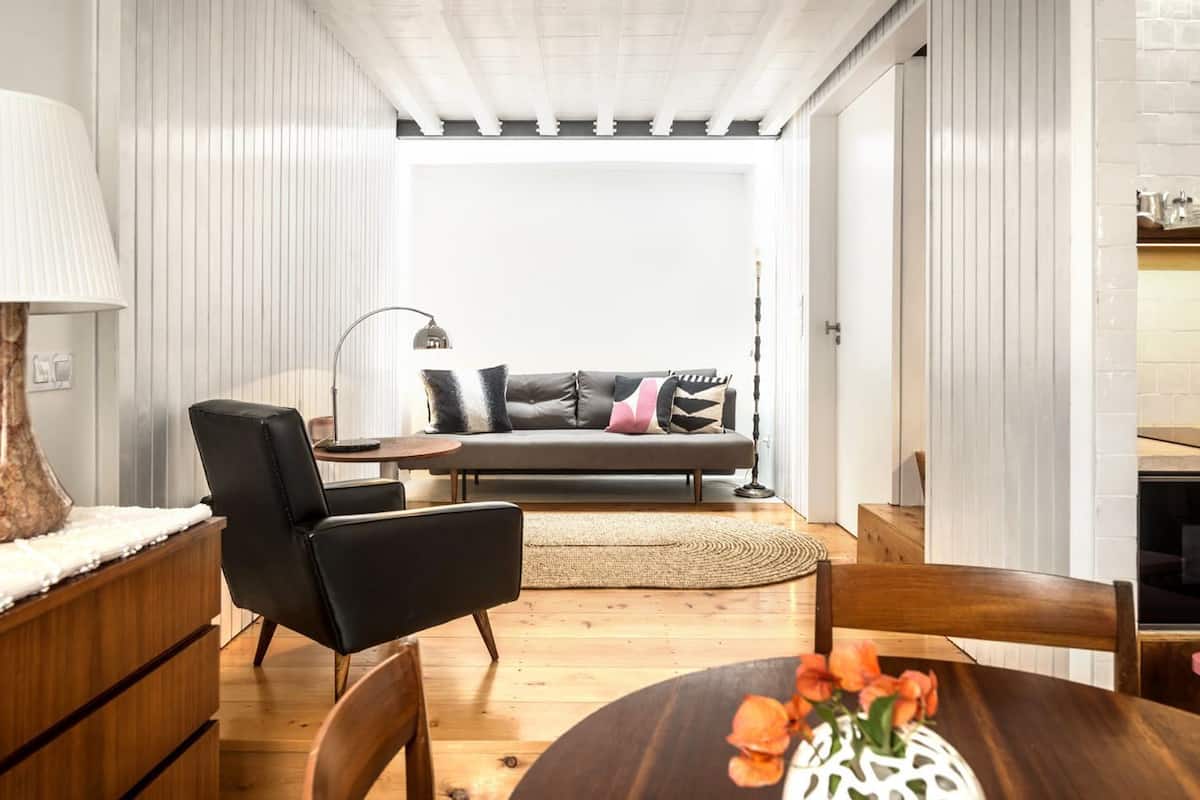A modern living room with a sofa, a coffee table, and a dining table.
