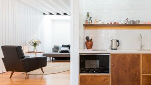 A modern kitchen with wooden cabinets, a built-in oven, and a white tiled backsplash. - Patio São Vicente Guest House (Lisbon)