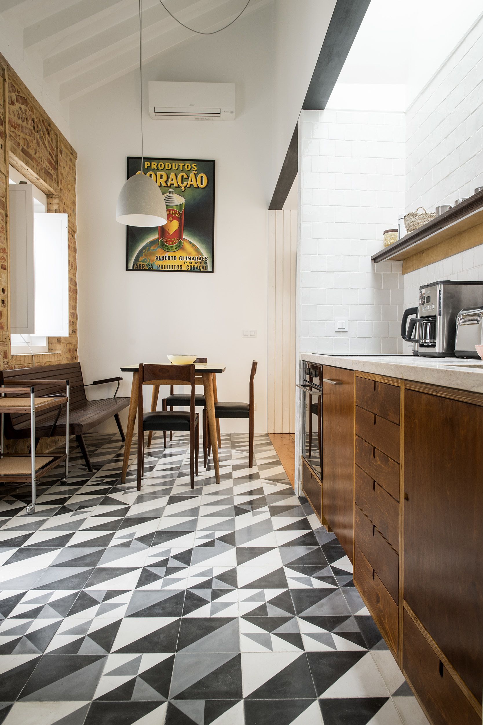 A kitchen with a geometric patterned floor, wooden cabinets, and a coffee machine.