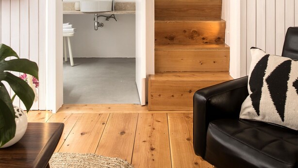 A staircase leading to a kitchen with white cabinetry and a wooden floor. - Patio São Vicente Guest House (Lisbon)
