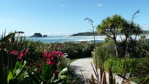 A pathway leading to a coastal view with lush greenery and distant islands.